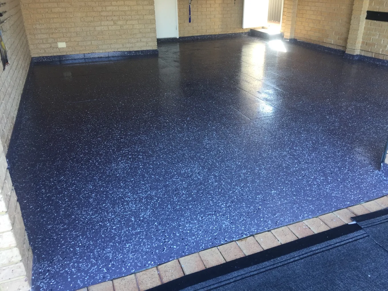 Onyx flake epoxy garage floor with a high-gloss finish over a dark base
