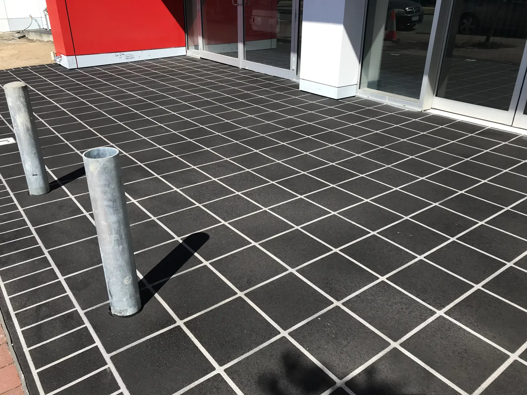 Charcoal stencil concrete forecourt laid in a diagonal square tile pattern with pale joint lines