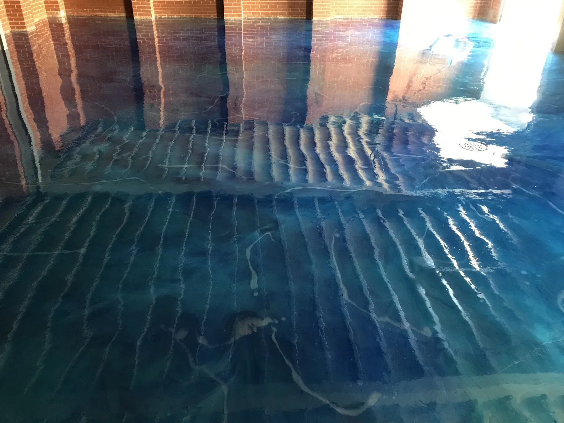 Metallic epoxy floor with a deep pearl swirl and gloss topcoat