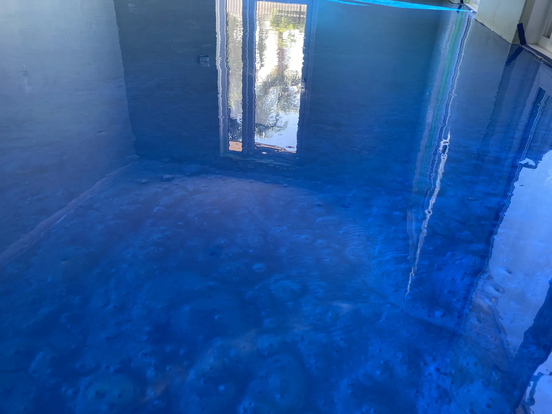 Bronze and blue metallic epoxy floor with pale marbled veining under a mirror gloss