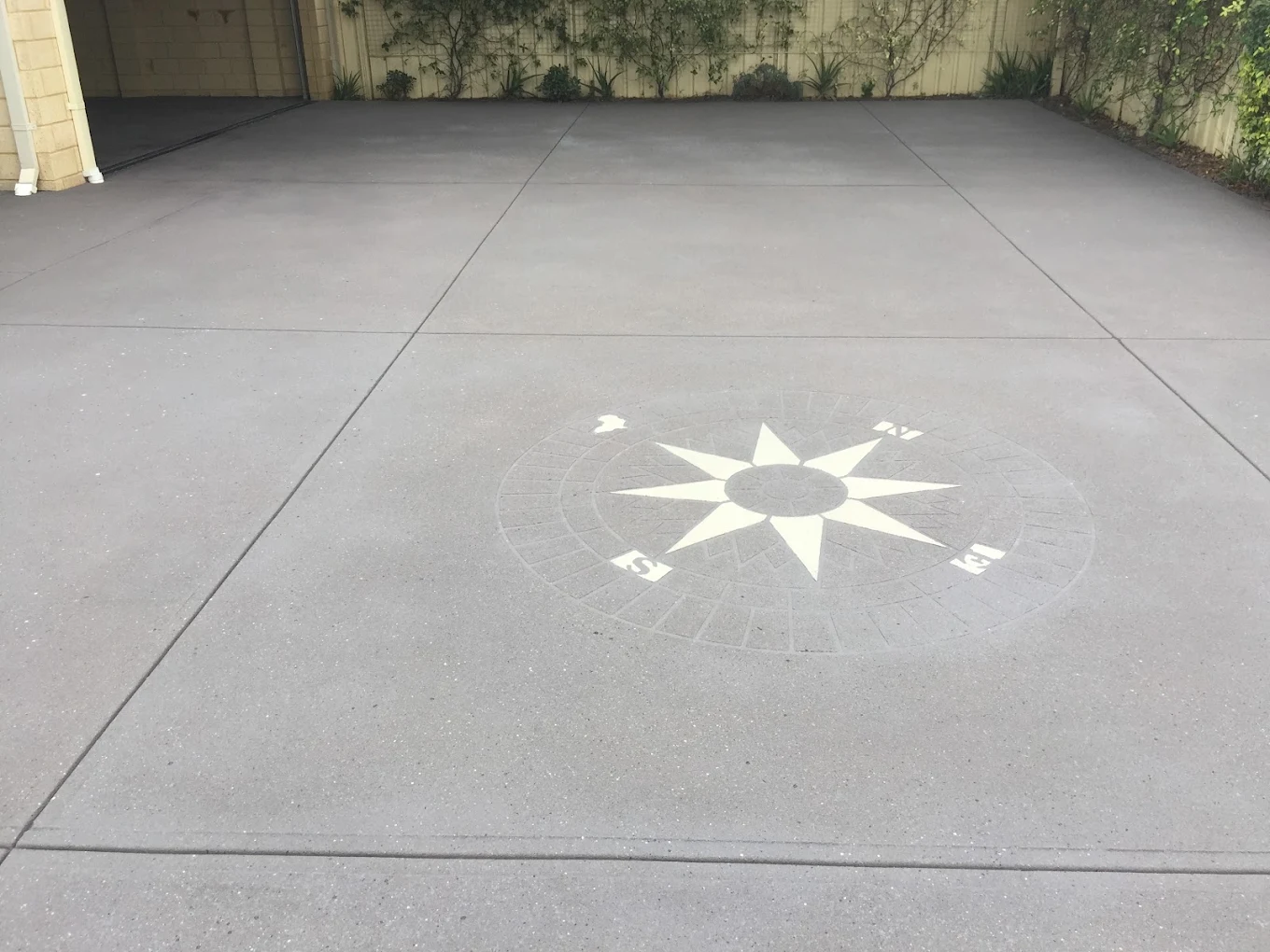 Spray-on paved driveway featuring a compass rose inlay pattern